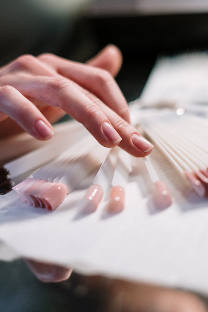 stats-img Close-up of a womans hand selecting nail polish colors in a beauty salon.